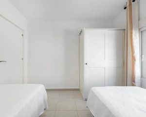 Habitación con dos camas individuales y armario
