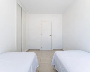 Habitación con dos camas individuales y armario